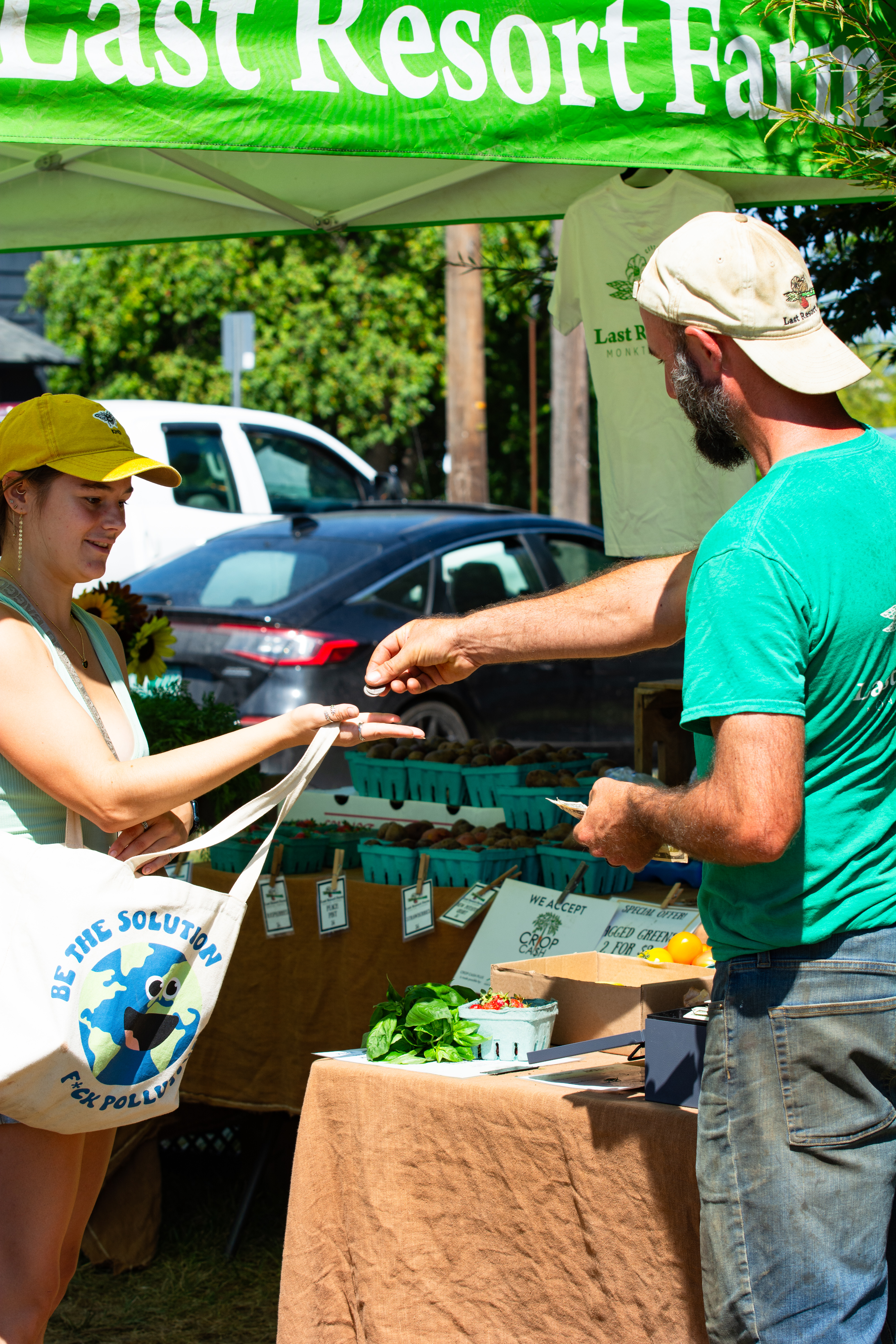 A customer receives change after a transaction with a farmer at a Vermont farmers market. 