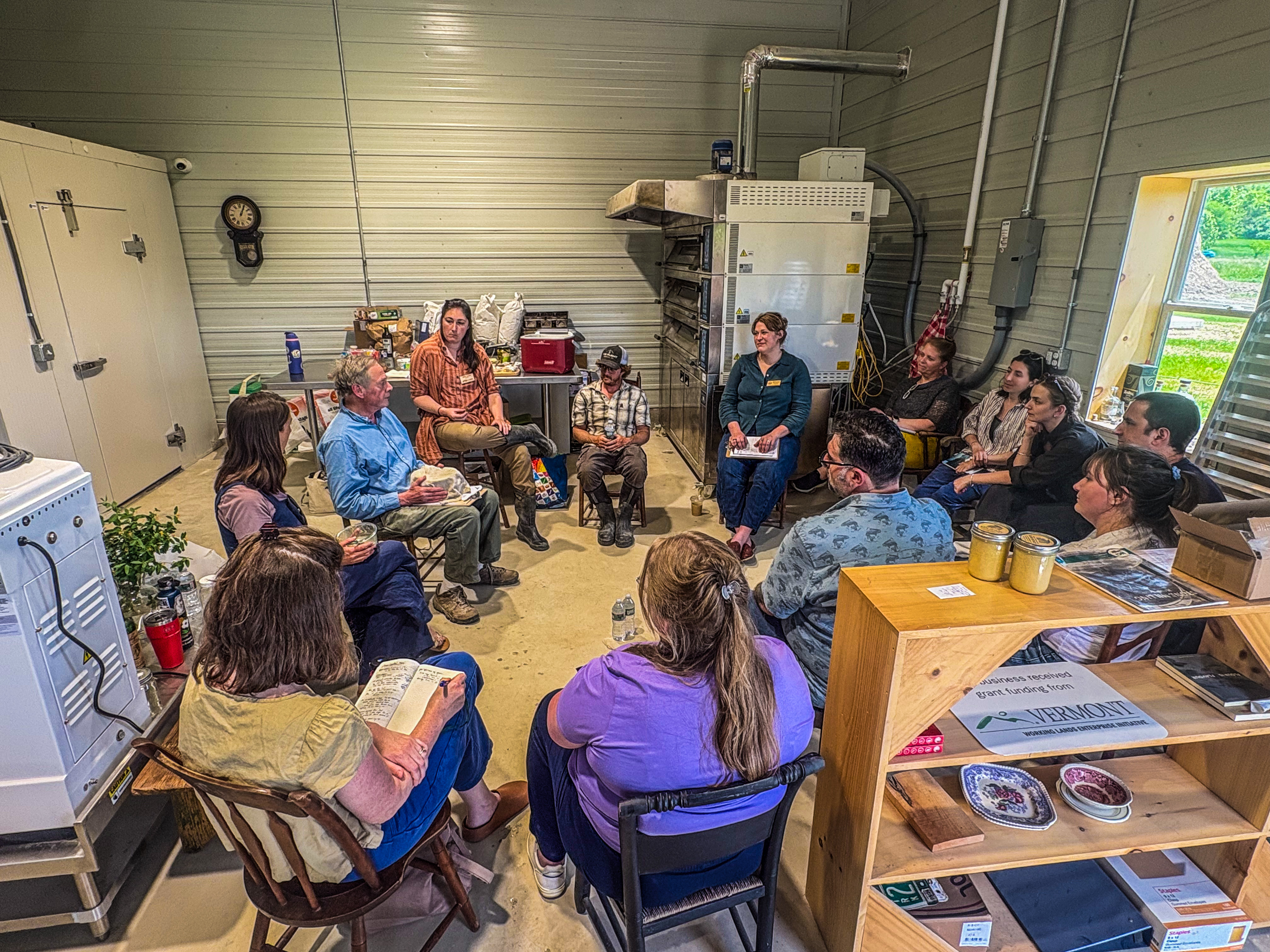 Institutional buyers from food hubs and Vermont school systems are seen seated in a circle at the Champlain Valley Grain Center chatting with Todd Hardie