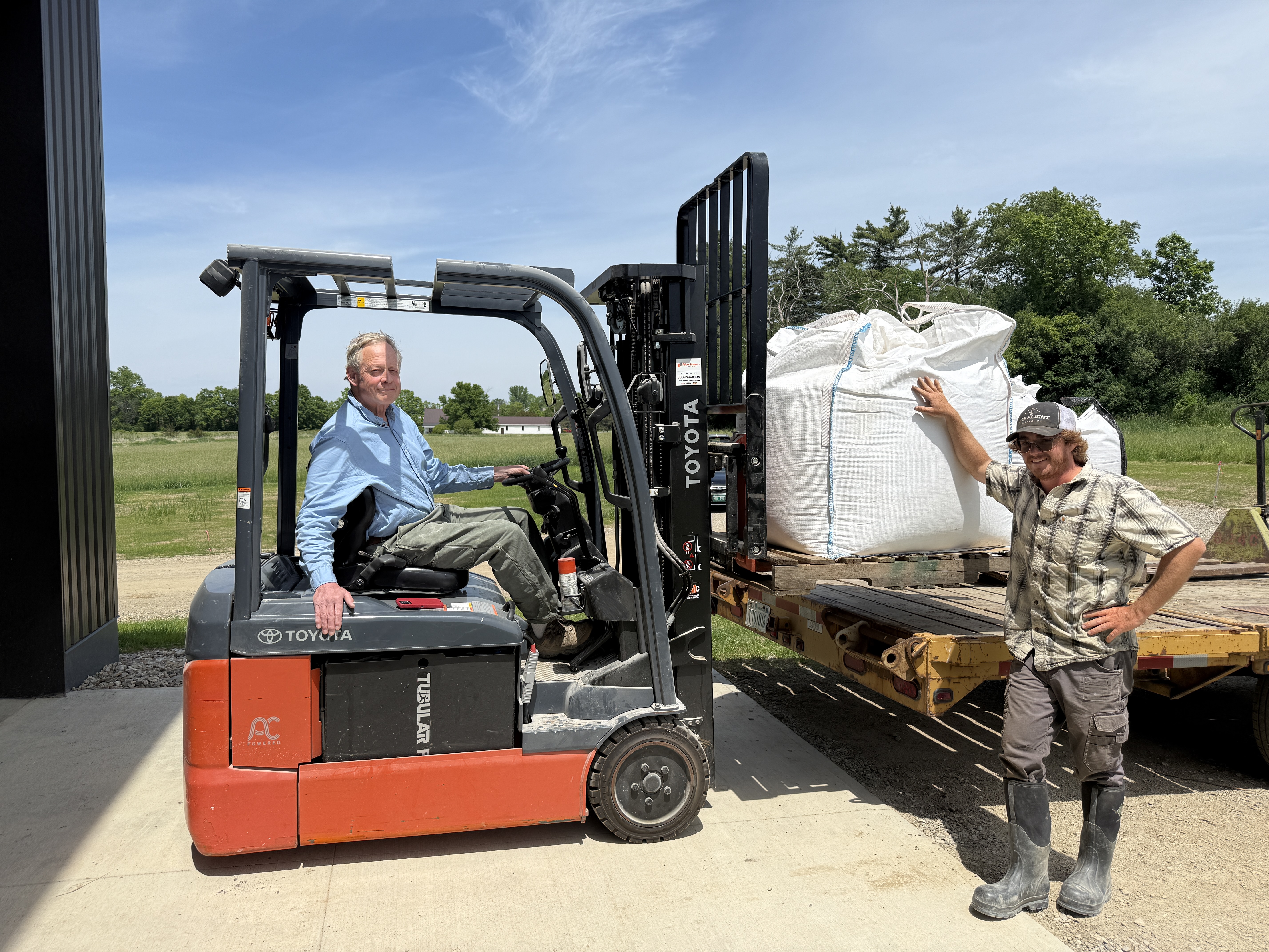 Todd Hardie of the Champlain Valley Grain Center is seen with another team member loading large sacks of locall-grown grain with a forklift