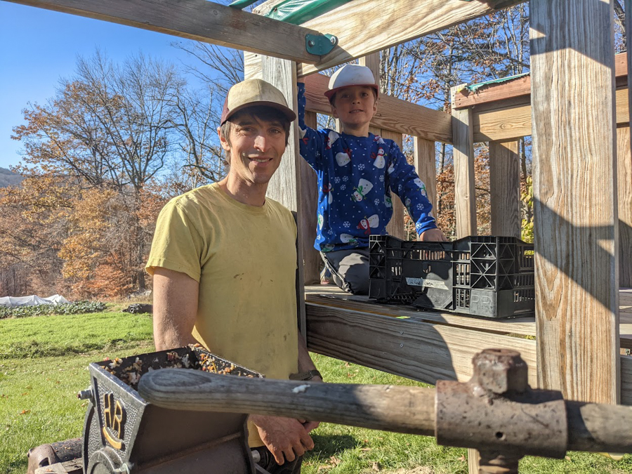 A farmer and a kid grind grain