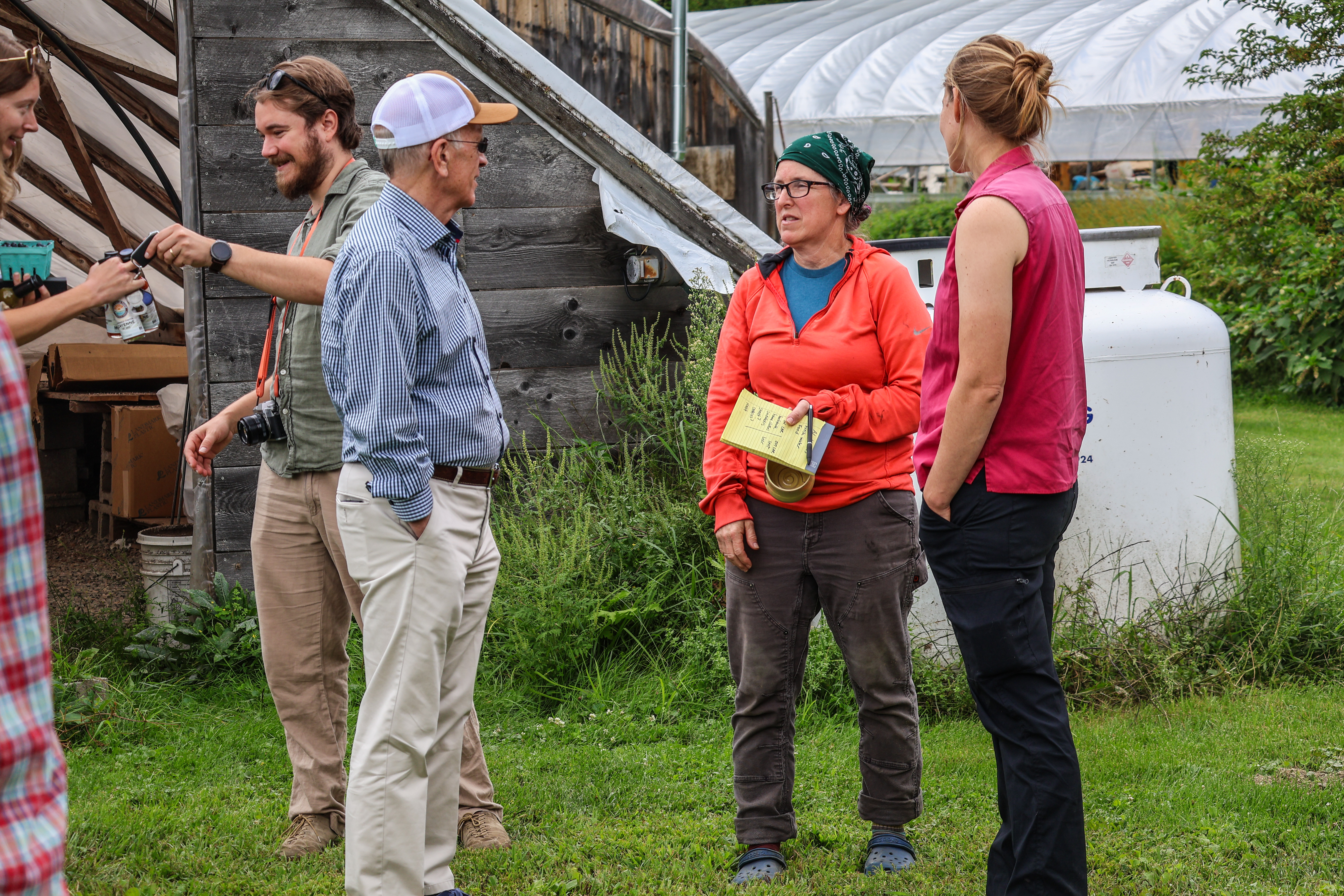 Amy Huyffer of Strafford Organic Creamery and Shona Sanford-Long of Flying Dog Farm speak with Senator Welch outside of a high tunnel at Honey Field Farm
