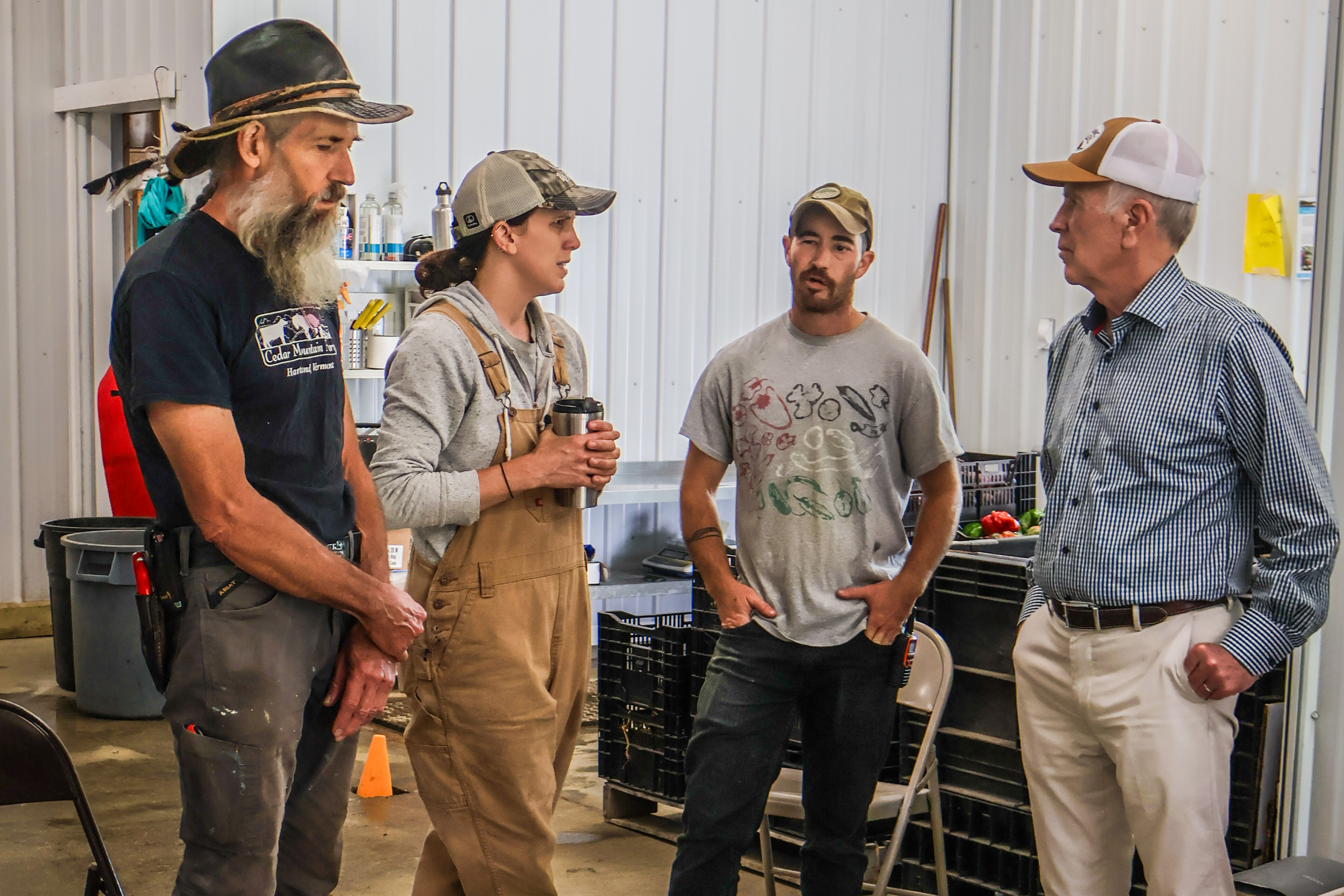 Stephen Leslie stands with Eli and Valerie Hersh of Honey Field Farm as the three farmers chat with Senator Welch during a roundtable discussion on the rural economic crisis