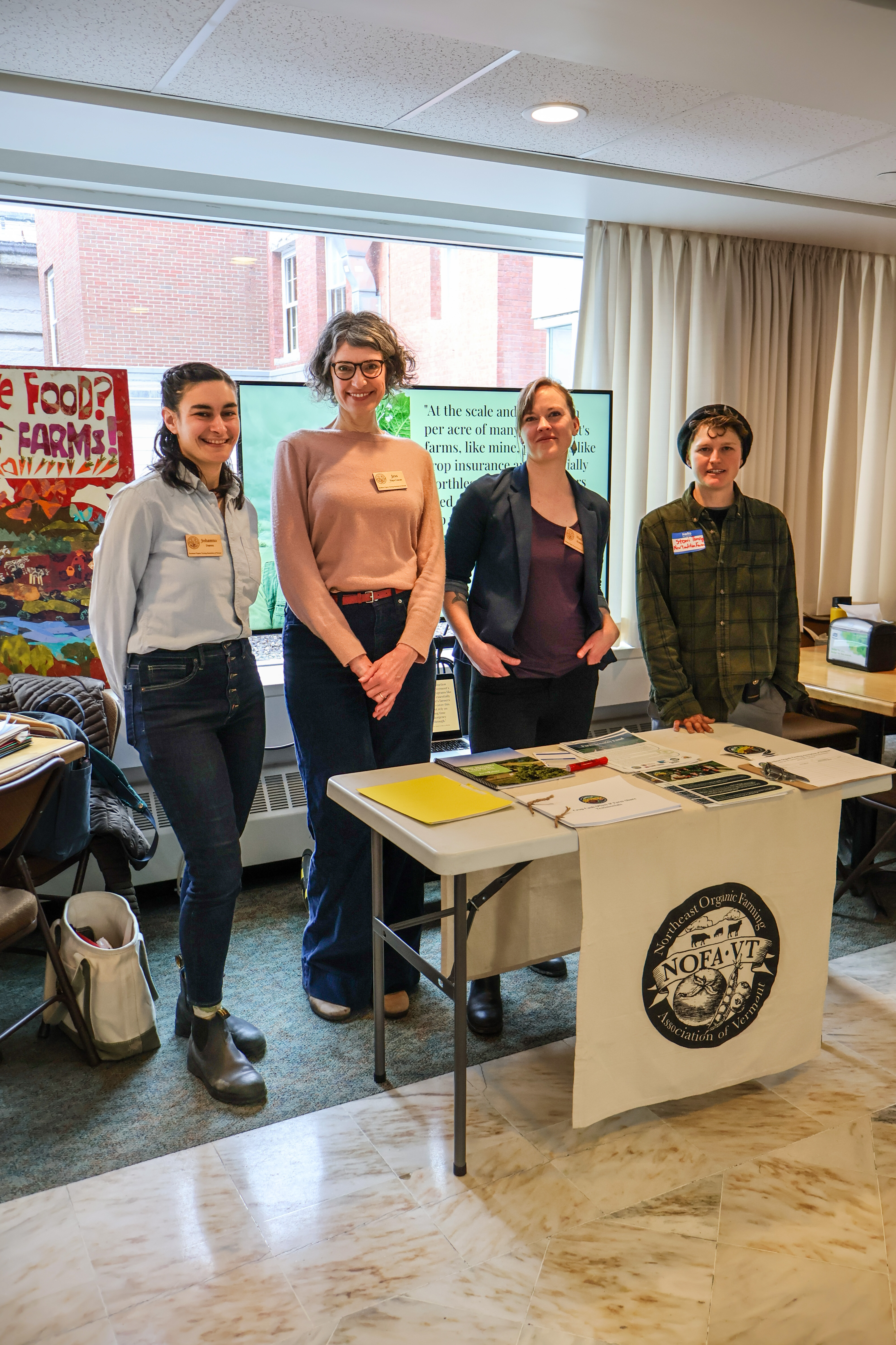 Johanna Doren, NOFA-VT Direct Markets & Local Food Access Program Director, Jessica Hays Lucas, NOFA-VT Grassroots Organizer, Maddie Kempner, NOFA-VT Policy & Organizing Director, and Stoni Tomson, NOFA-VT farmer-member from New Tradition Farm table at an event at the Vermont State House to spread awareness and gain support for the Farm Security Fund