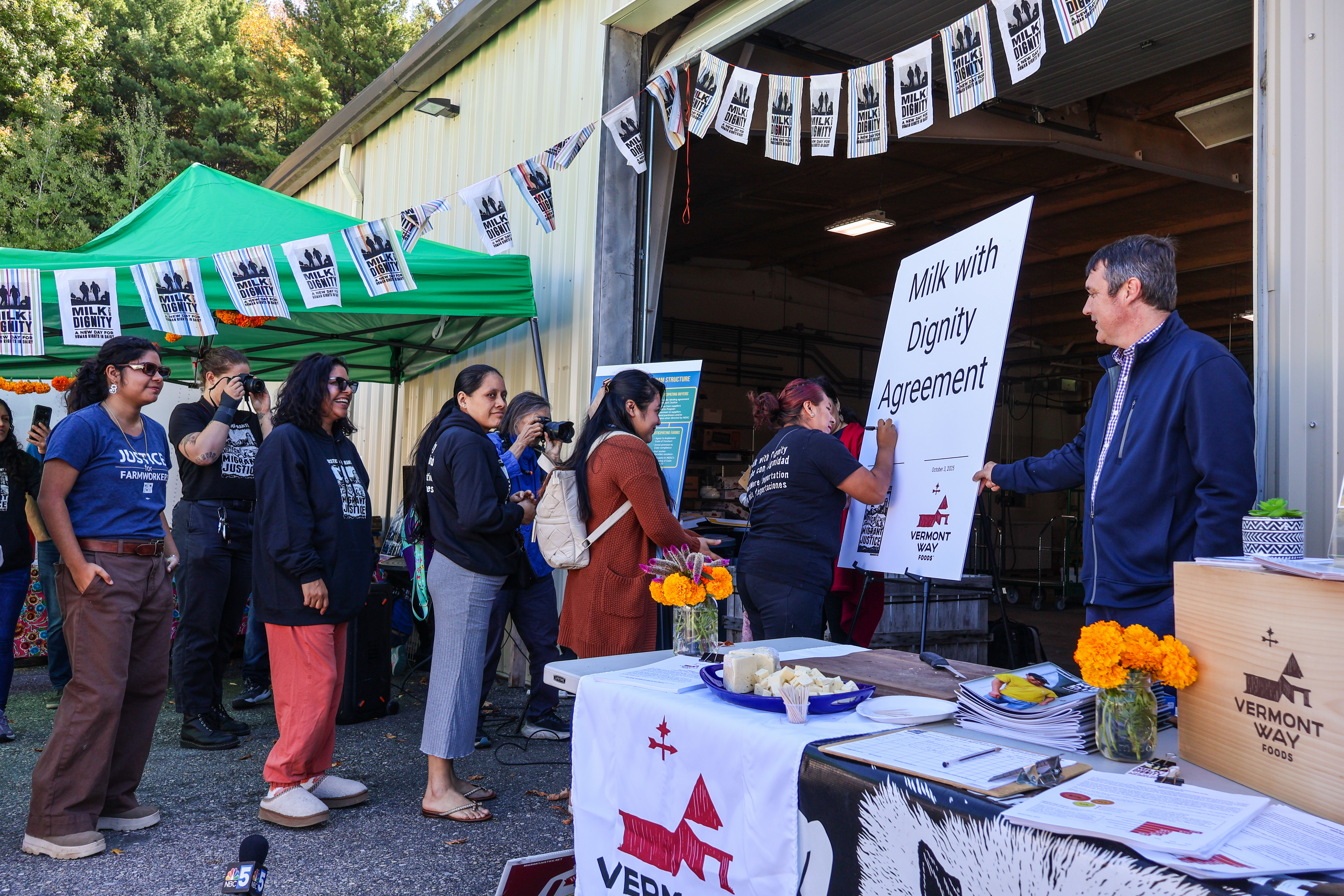 migrant farmworkers line up to sign the new Milk With Dignity agreement between Migrant Justice and Vermont Way Foods