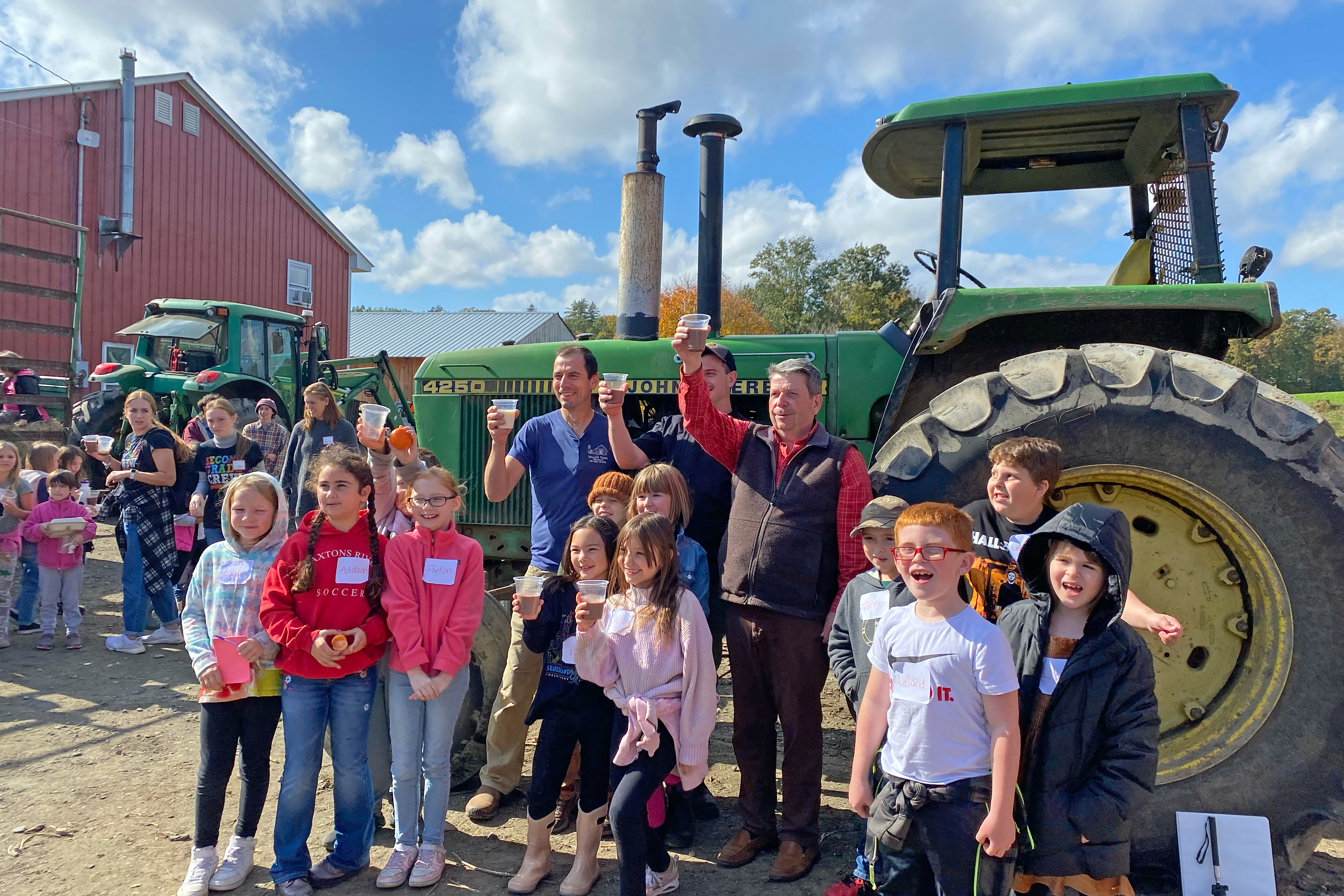 Students from Windham Supervisory Union raise a glass of chocolate milk with Peter Miller of Miller Farm, Harley Sterling, WSESU school nutrition director, and Anson Tebbetts, VT Secretary of Agriculture, Food and Markets, at on on-farm event celebrating a local milk for local schools project atat Miller Farm