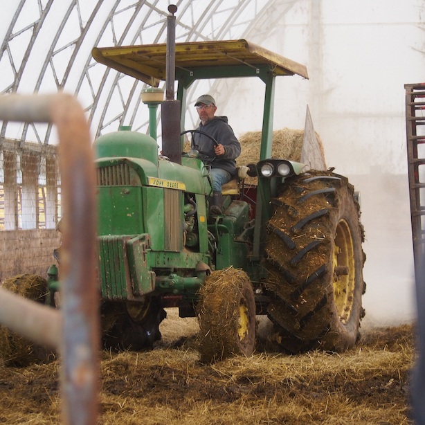 Guy Choiniere moving hay on Choiniere Family Farm in Highgate, Vermont