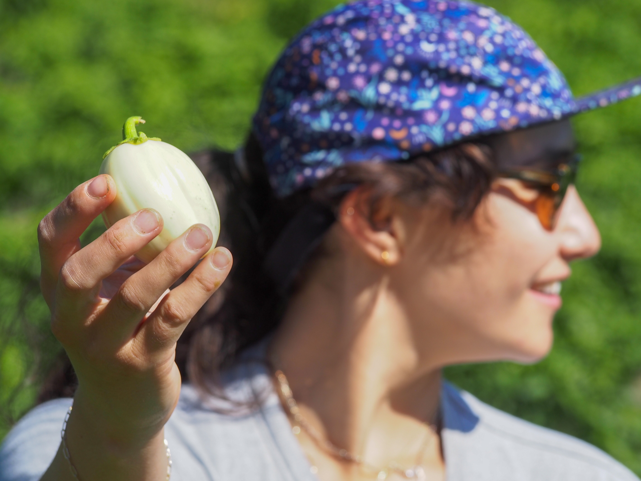 Sadie Bloch holds up a White African Eggplant harvested at Pine Island Community Farm in Colchester, VT.