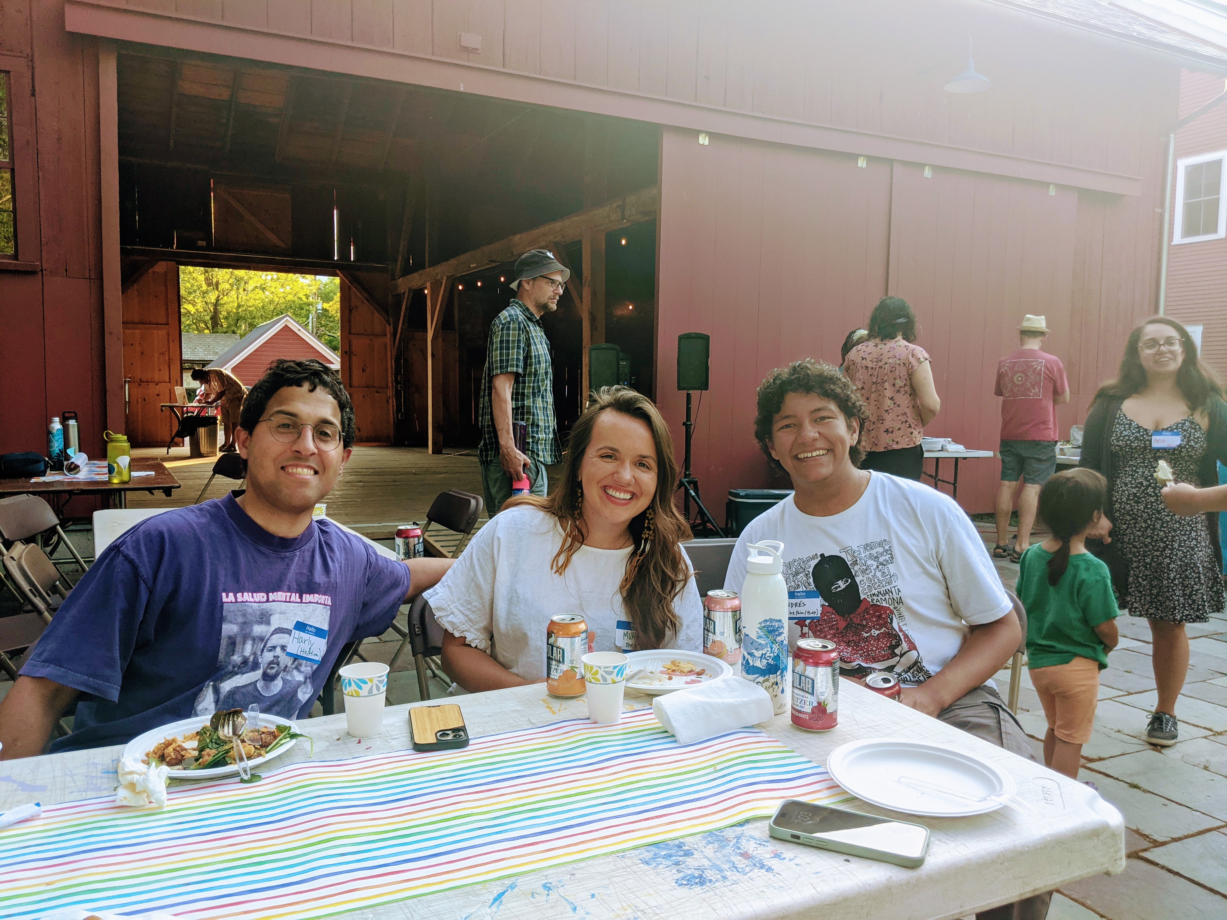 Members of Liberation Ecosystem, Inc. smiling as they sit around a table at a community event