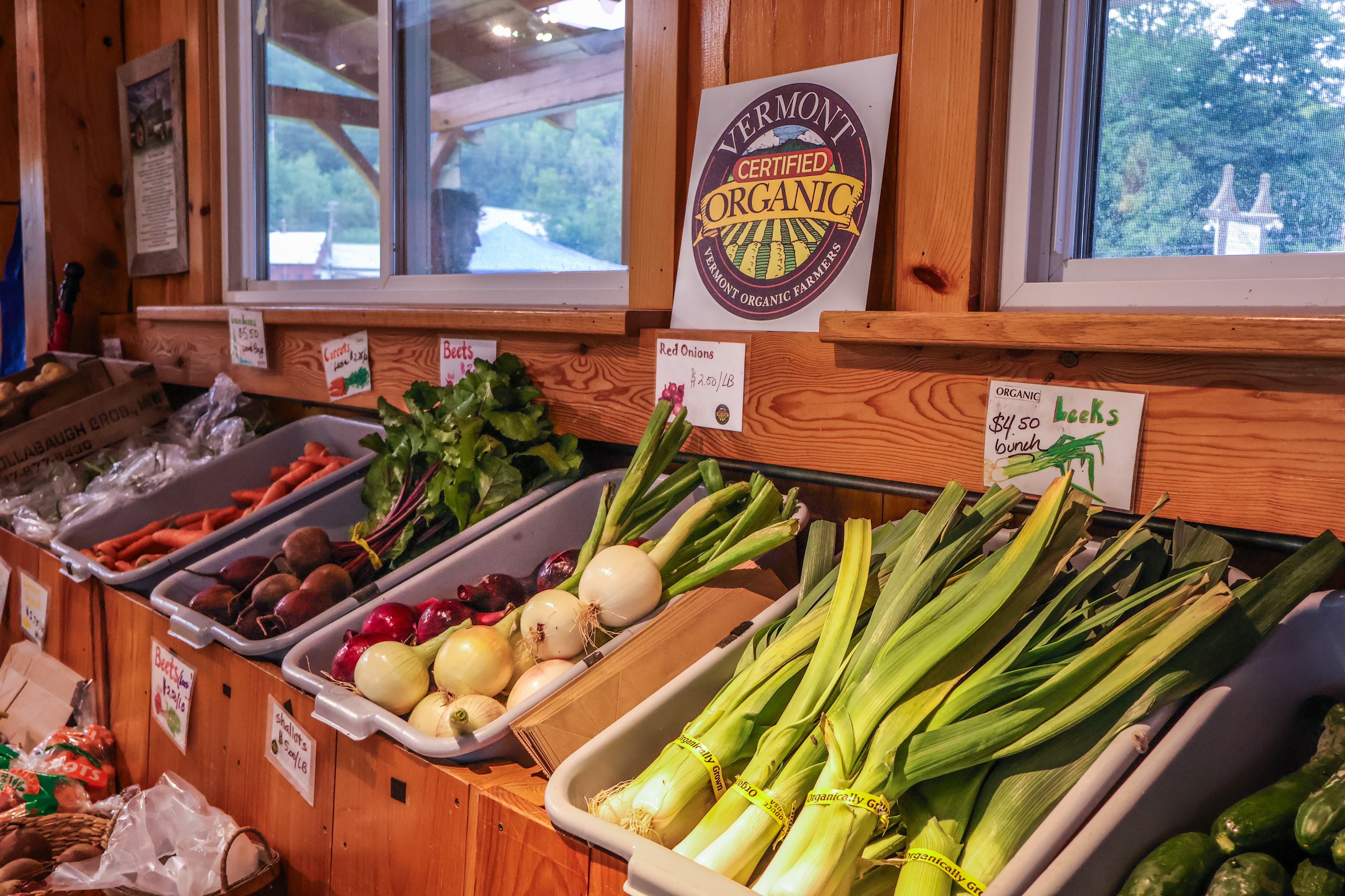 A colorful display of produce at the Foote Brook Farm farm stand with a Vermont Certified Organic seal