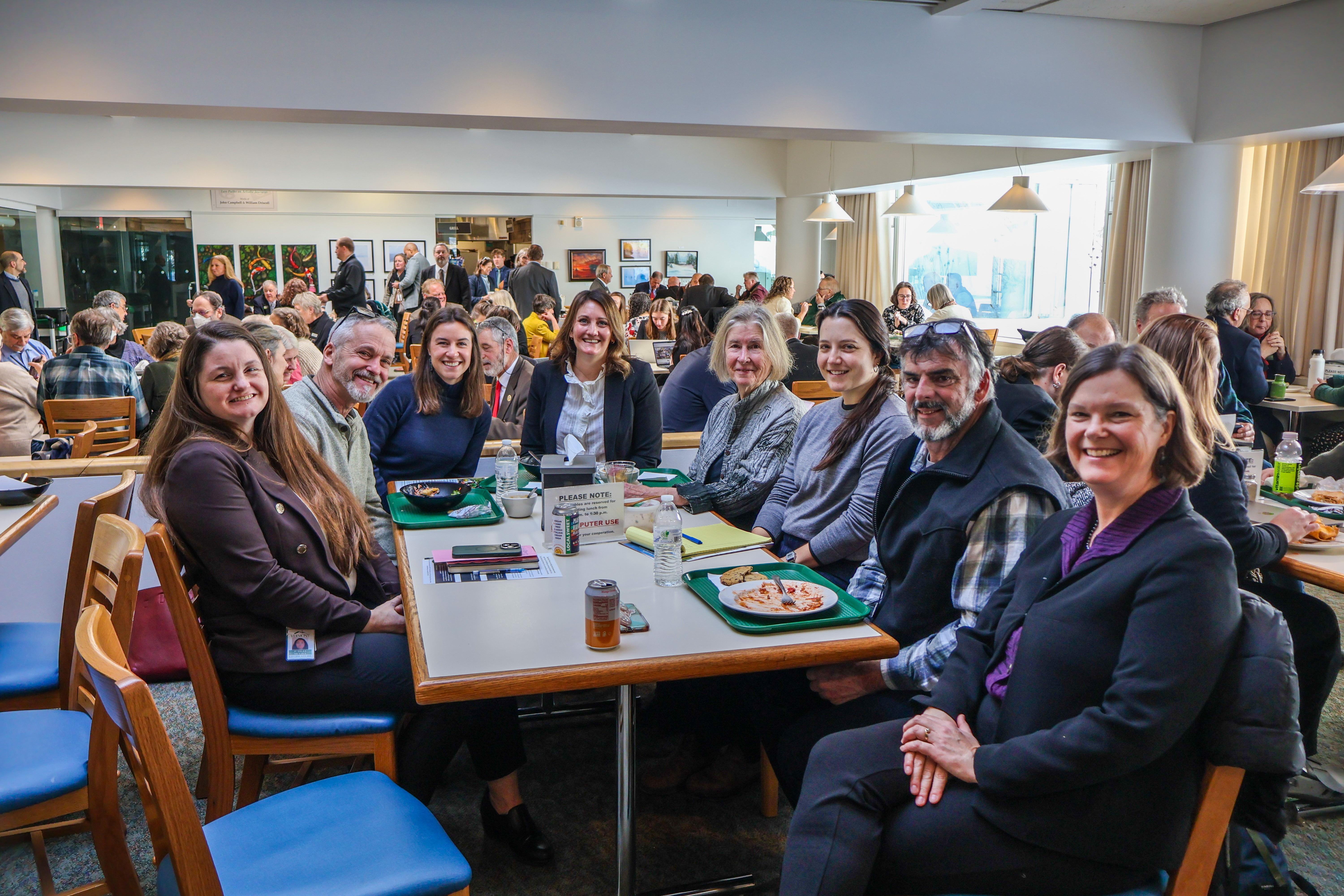 NOFA-VT members and allies sit at a State House cafeteria table chatting with Representative Jubilee McGill and Senator Ruth Hardy about NOFA-VT's policy priorities during a recent State House Day.
