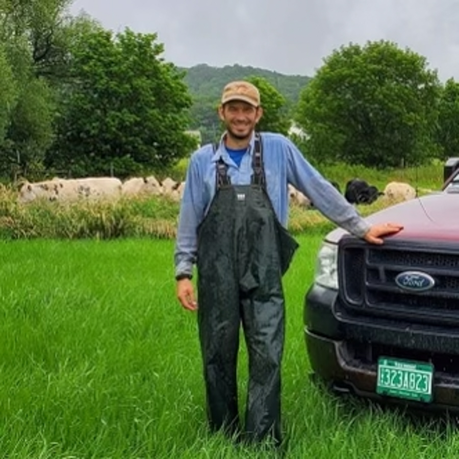 Farmer leans up against tuck