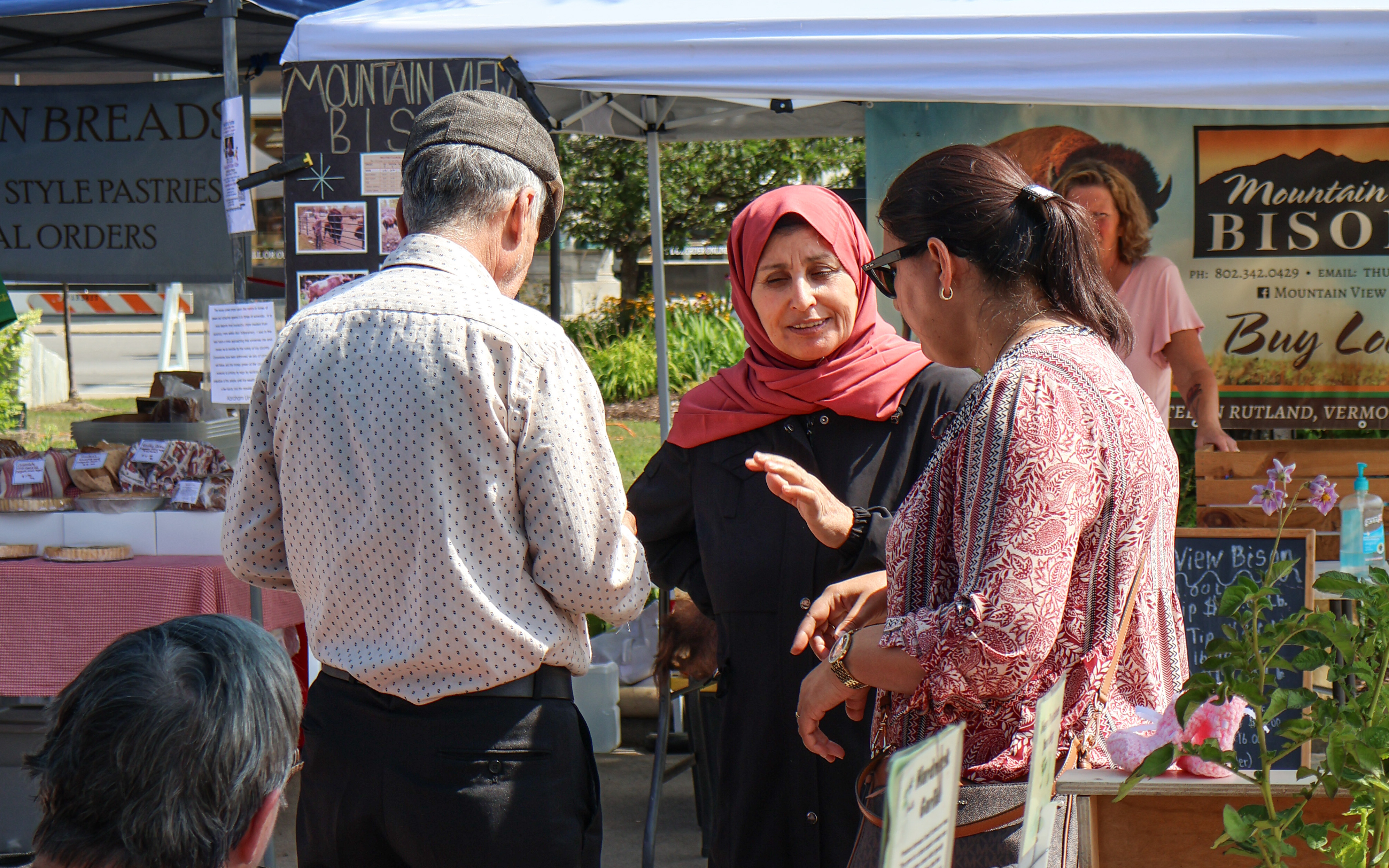Translation services being provided to non-English speaking customers at the Vermont Farmers market in Rutland as part of a NOFA-VT event aimed at improving communication about programs like Crop Cash.