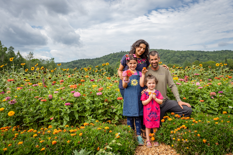 A family smiles in a biodiverse field