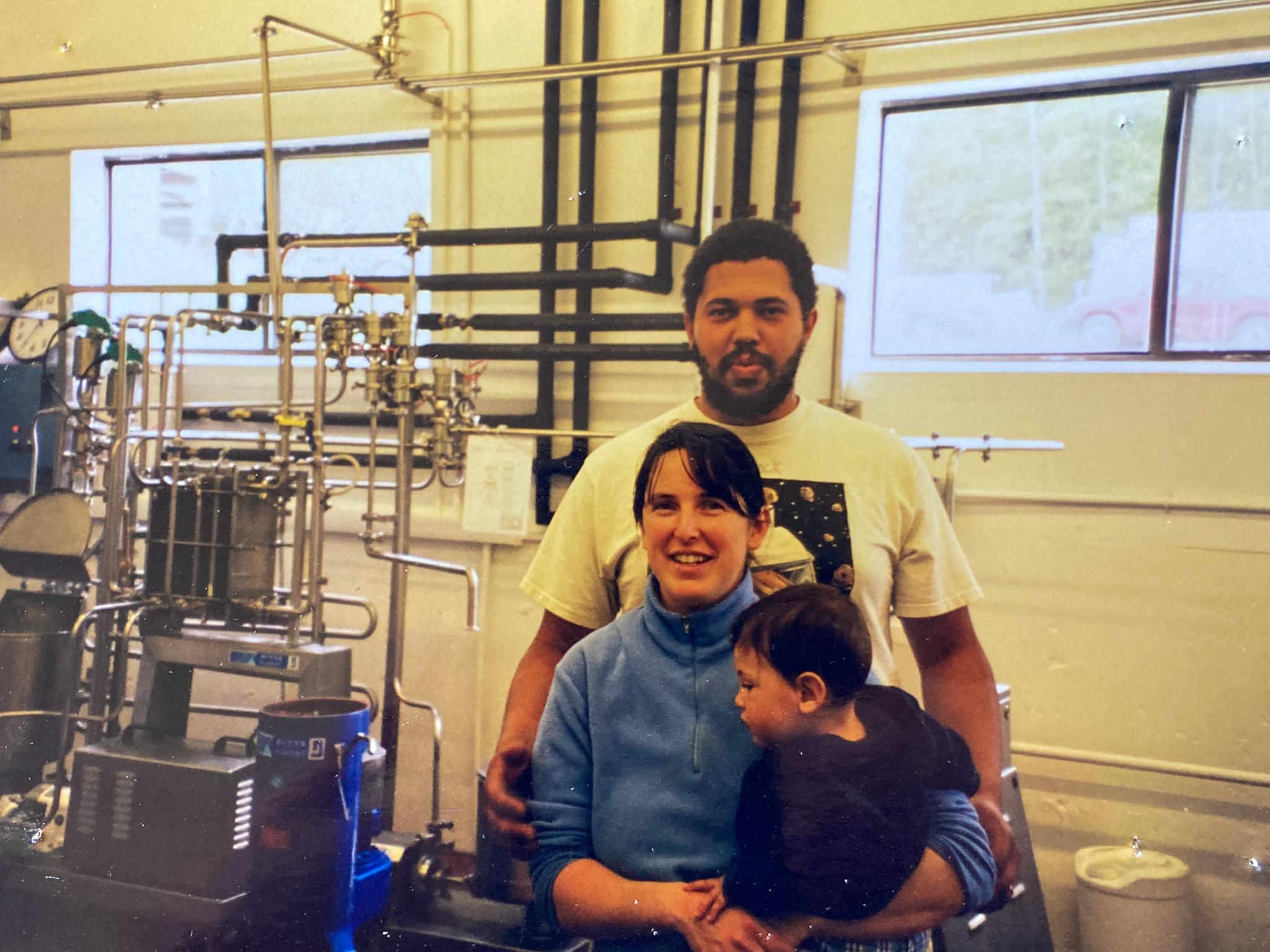 A young family is inside a building at Strafford Organic Creamery in an old analog, color photo.