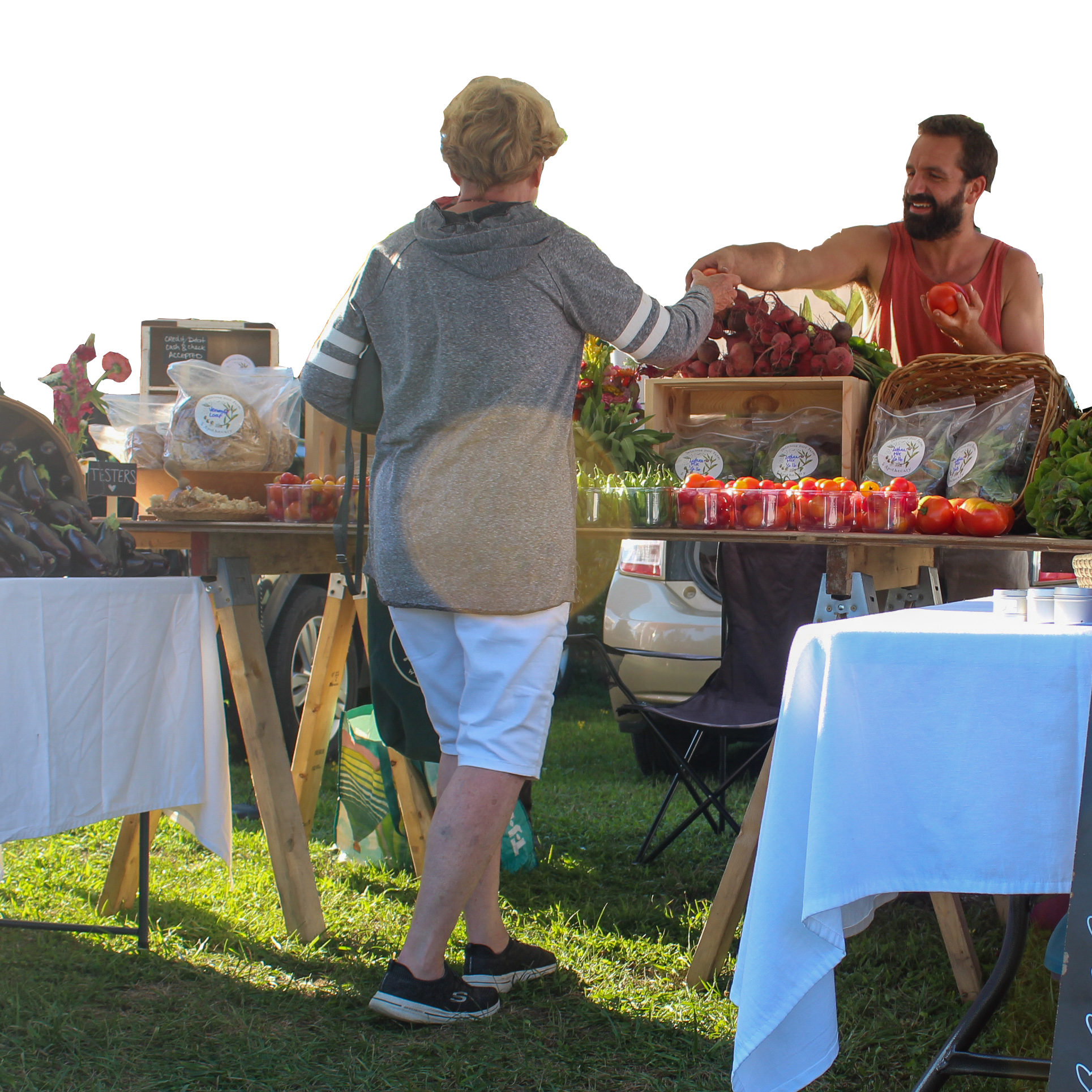 A customer buys produce at a farmers market stand.