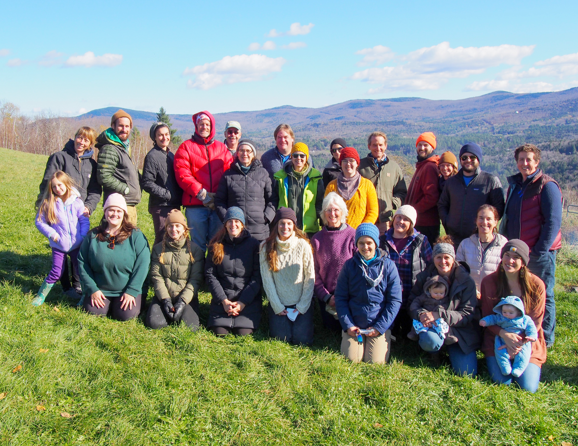 The NOFA-VT staff and board stands outside in a group, smiling at the camera.