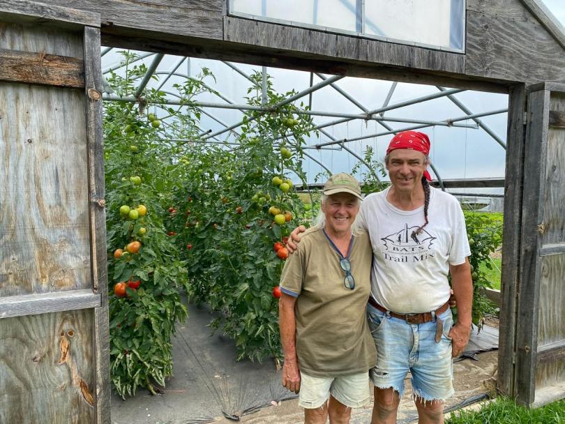 John and Joy in front of a greenhouse