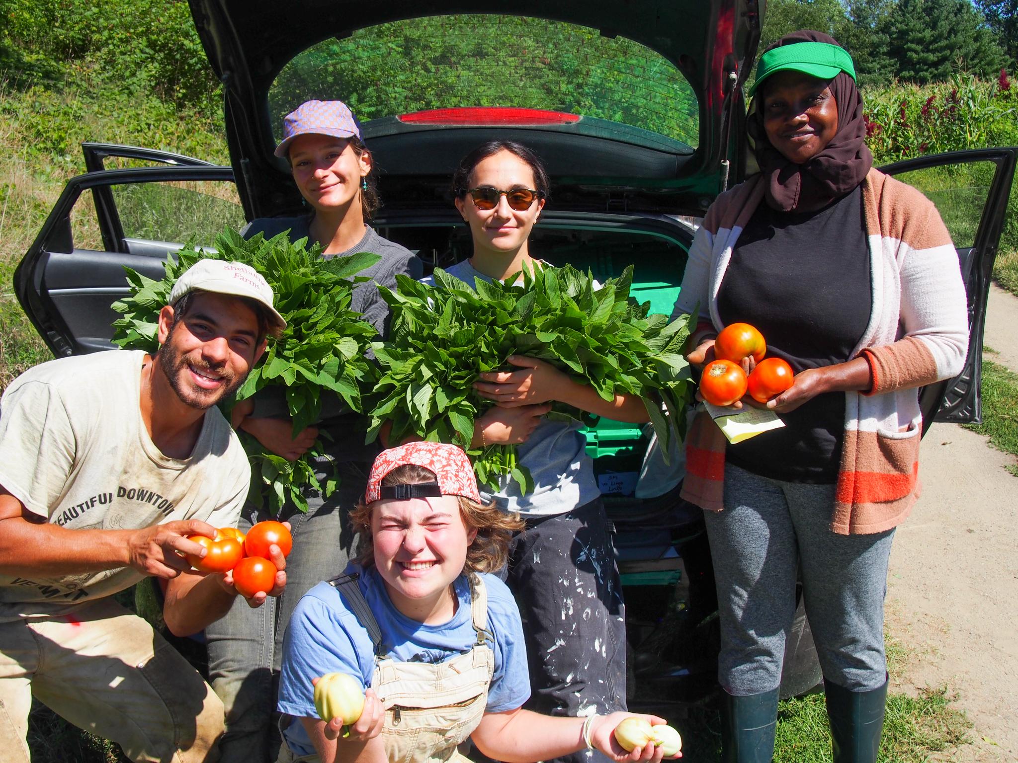 The People's Farmstand volunteers and organizers pose with vegetables they harvested for their free community farmstand events
