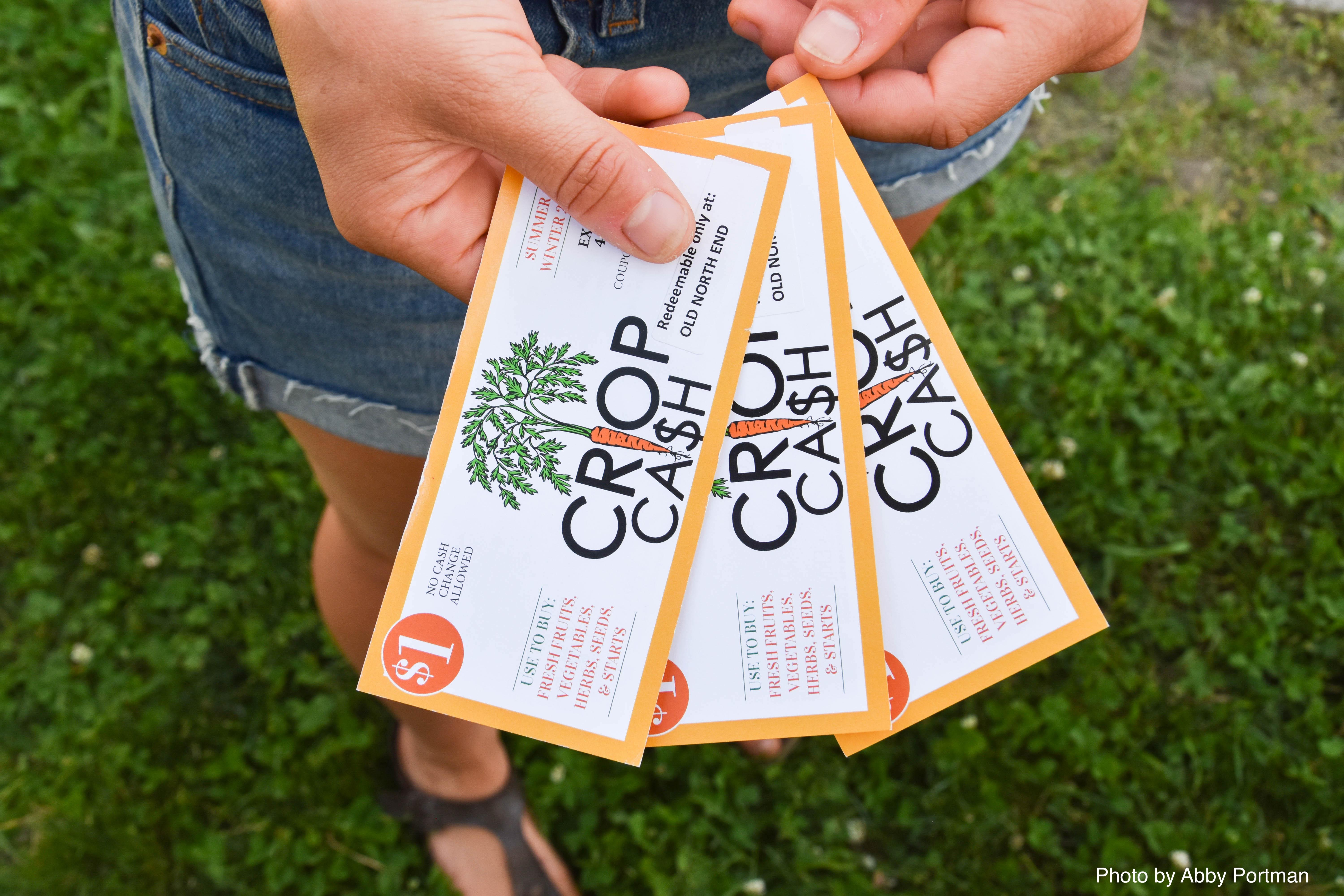 Farmers market shopper holding crop cash coupons