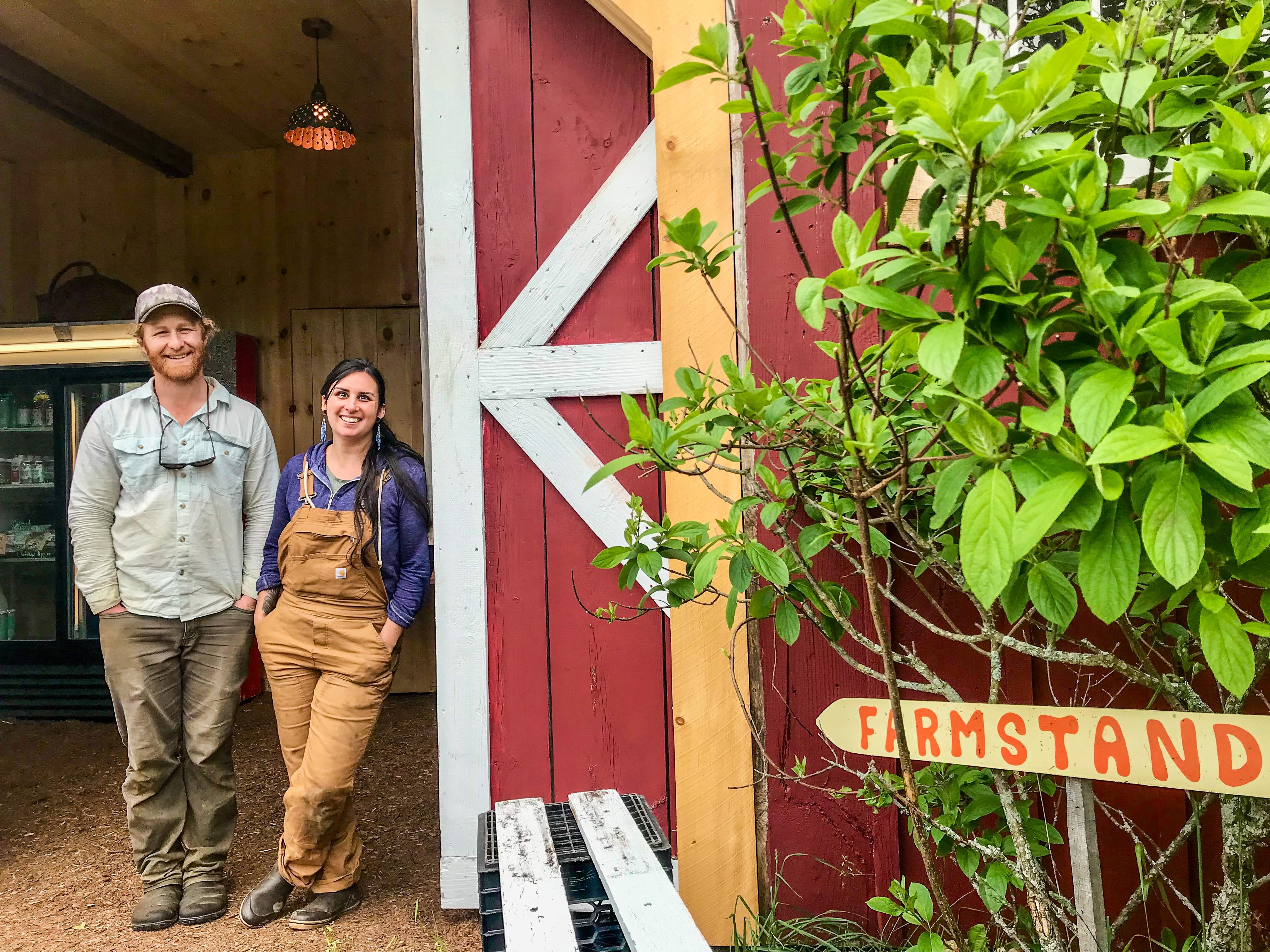 Farmers Jessica Purks and Connor Self of Stone's Throw Farmstead stand in the doorway of their new farmstand 