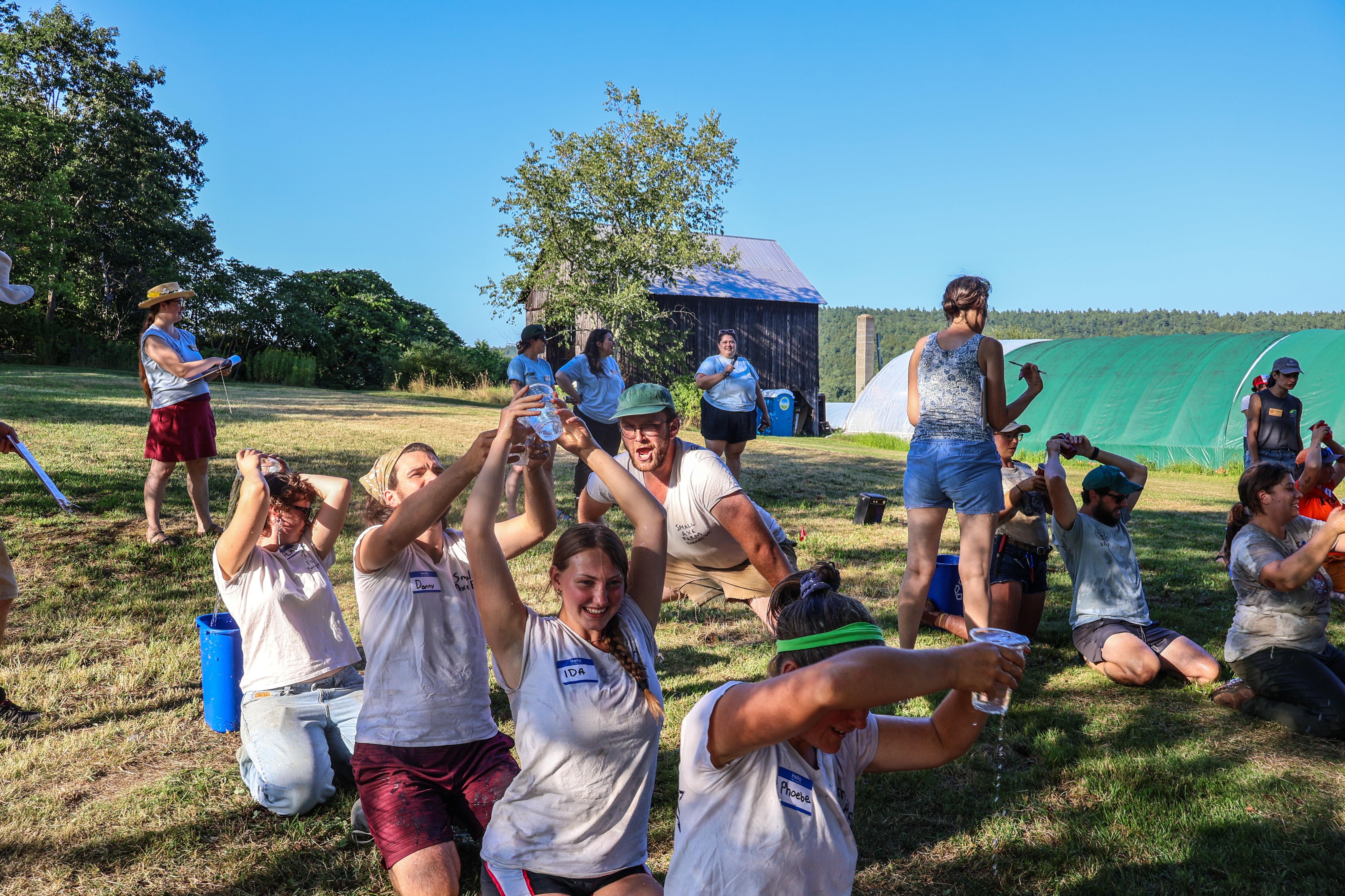 Farmers participate in a water pouring relay as part of the 2025 Farmer Olympics at High Meadows Farm