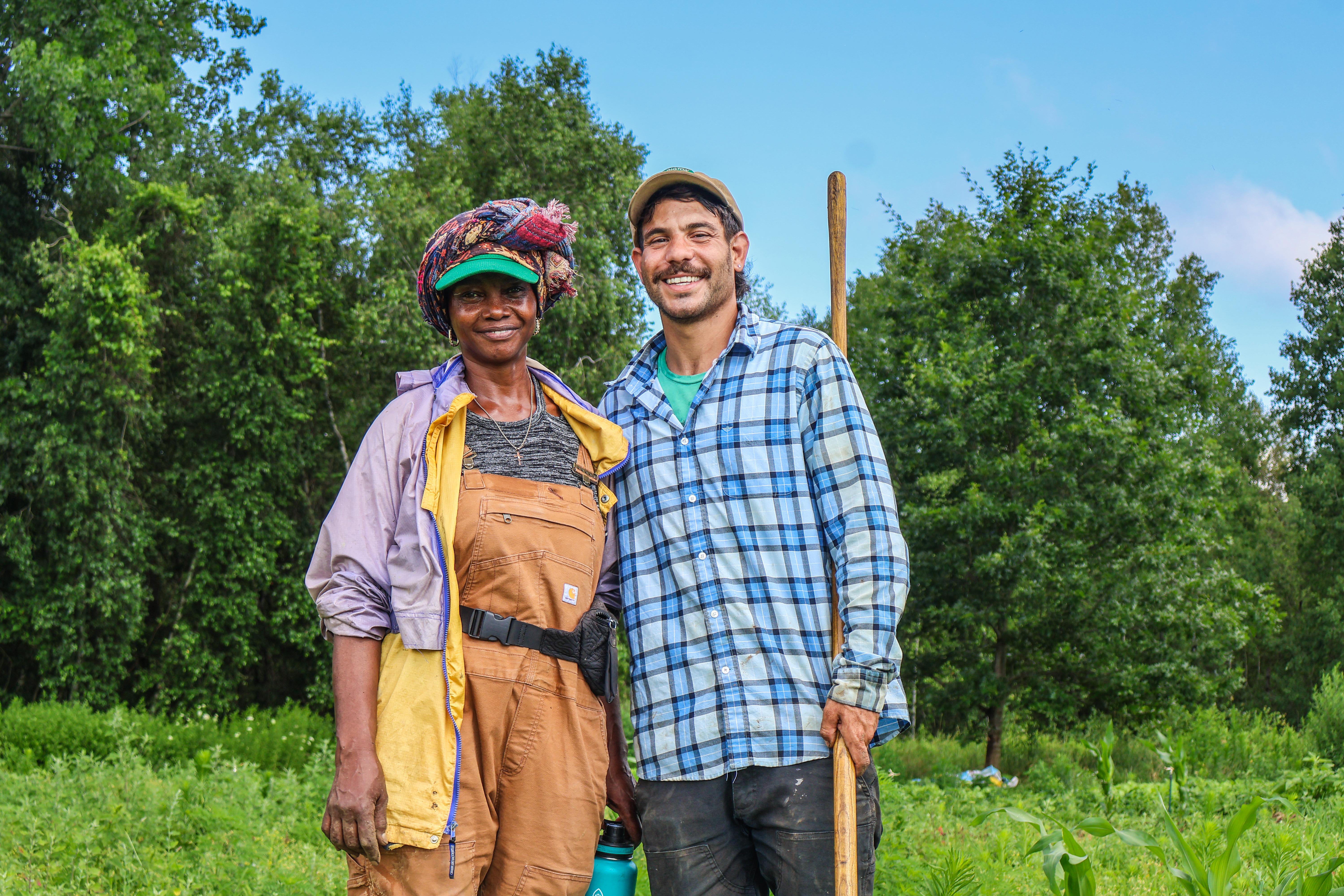 Hyacinthe Ayingeneye of Mama's Farm stands smiling in her farm field with Nour El-Naboulsi of The People's Farmstand