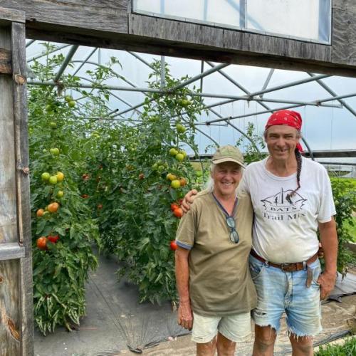 John and Joy in front of a greenhouse