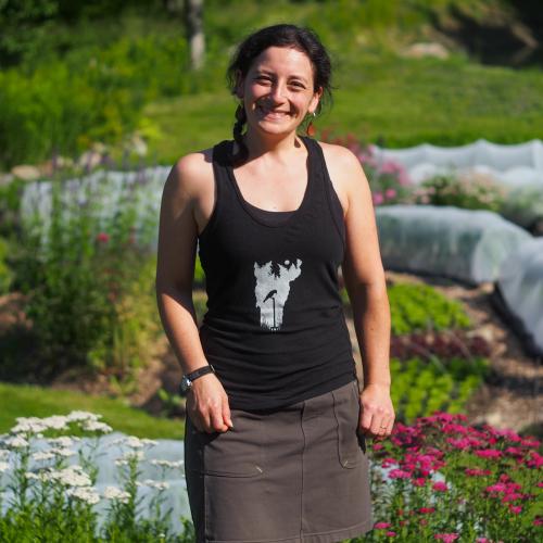 Liz Echeverria of Hawthorn Meadow Farmstead standing in front of garden beds