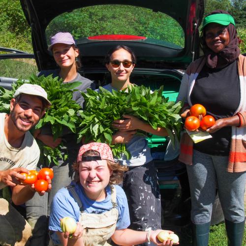 The People's Farmstand volunteers and organizers pose with vegetables they harvested for their free community farmstand events