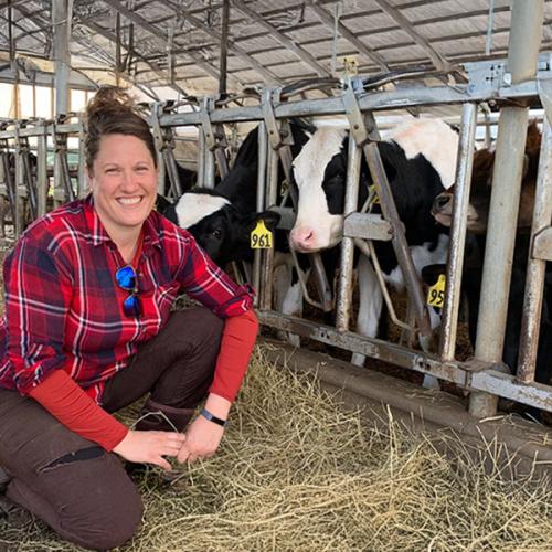 Abbie Corse of Corse Farm Dairy poses with her cows in the barn