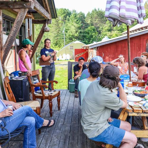 A group of beginning and aspiring farmers gathers on the patio at Union Brook Farm while listing to Megan Browning and Em Virzi share insights into starting a farm