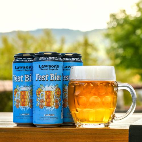 Lawson's Finest Liquids Fest Bier 4-pack sitting next to a clear mug full of beer on a table outside