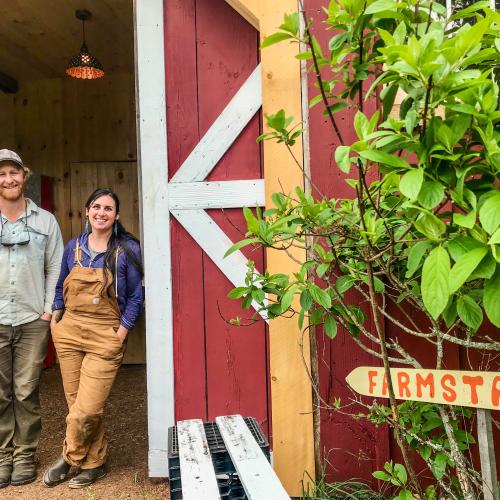 Farmers Jessica Purks and Connor Self of Stone's Throw Farmstead stand in the doorway of their new farmstand 