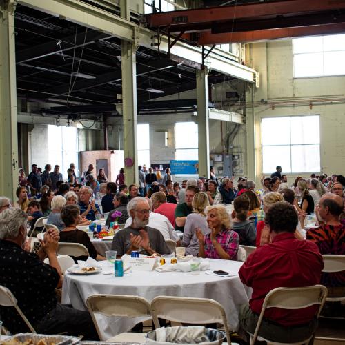 People sitting around tables in a hall