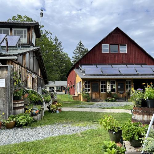 Red farmhouse and wooden farmstand
