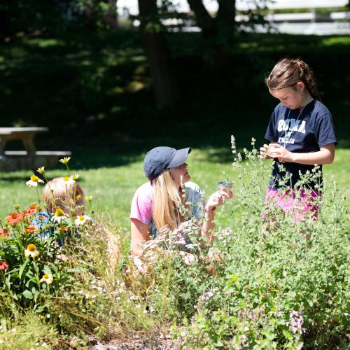 Educator and children in flowers