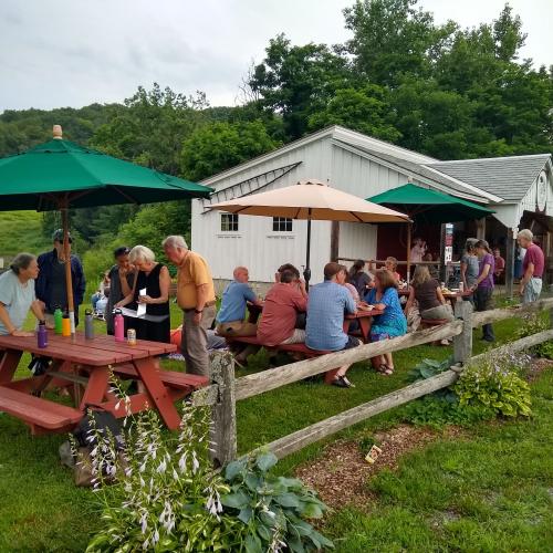 group sitting at picnic tables at farm