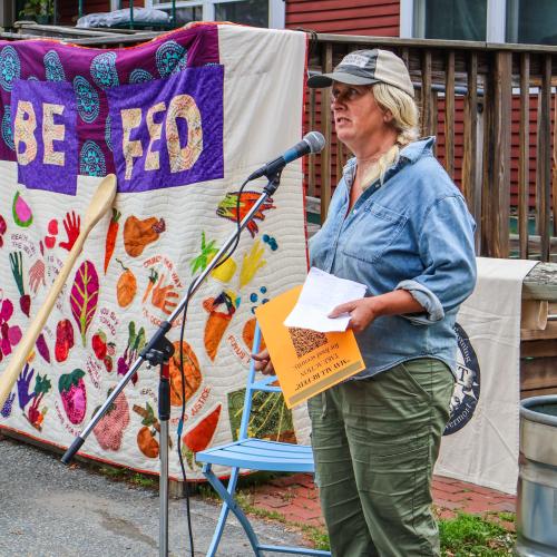 Margaret Loftus speaking into a microphone at an Upper Valley Farmer Day of Action hosted by NOFA-VT