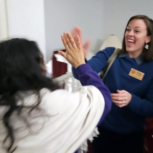 NOFA-VT Policy & Organizing Director Maddie Kempner high-fives NOFA-VT farmer member Melisa Oliva of Ananda Gardens in the hall of the State House upon hearing that S.60 passed the Vermont legislature